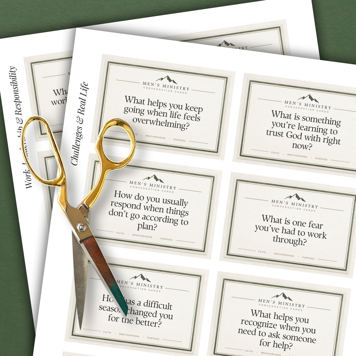 Printed worksheet or journaling cards for men's ministry, shown on a sheet with gold-handled scissors. The cards feature motivational or reflective prompts in black text with a small mountain logo and the words 'MEN'S MINISTERY' at the top.